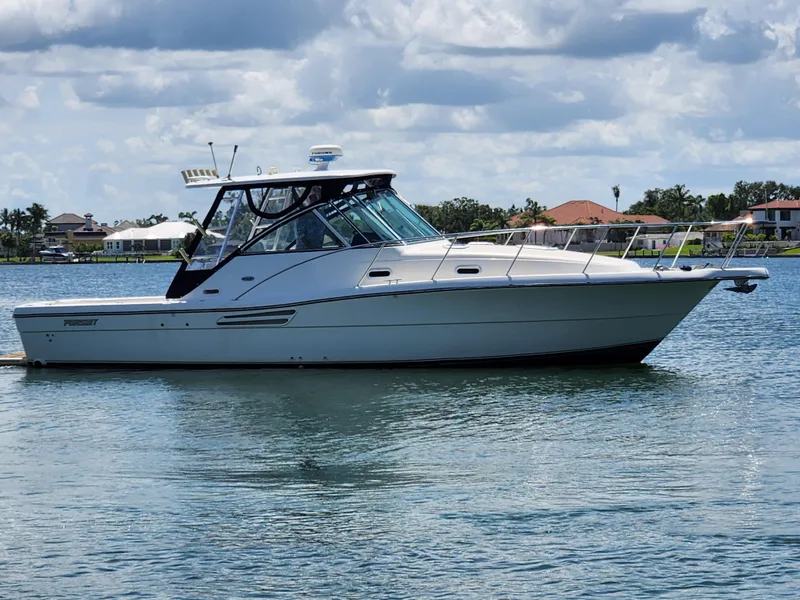 Slide: The Image of 2003 Pursuit 3000 Express boat on calm water under a cloudy sky. - 2