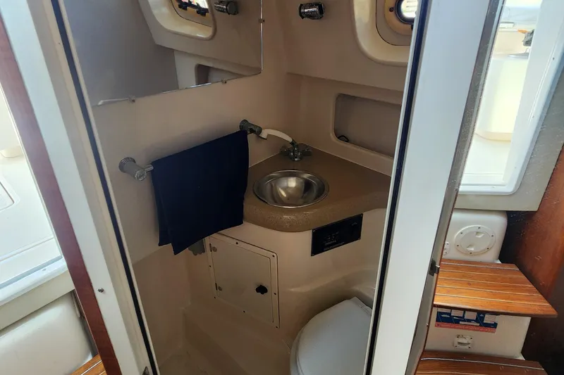 Slide: The Image of 2003 Pursuit 3000 Express boat bathroom with sink, towel, and toilet. - 20