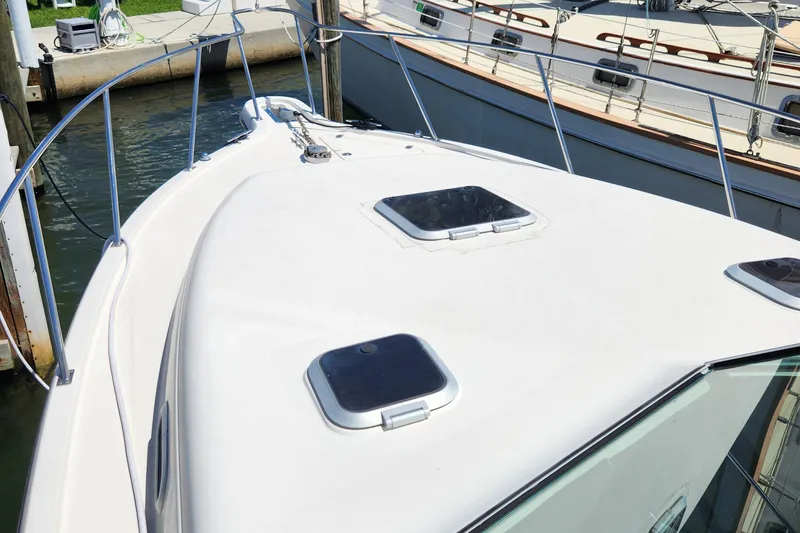 Slide: The Image of 2003 Pursuit 3000 Express boat deck with hatches, docked at marina. - 3