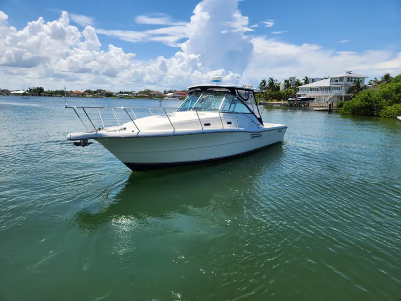Slide: The Image of 2003 Pursuit 3000 Express boat deck with hatch, docked by the water. - 4