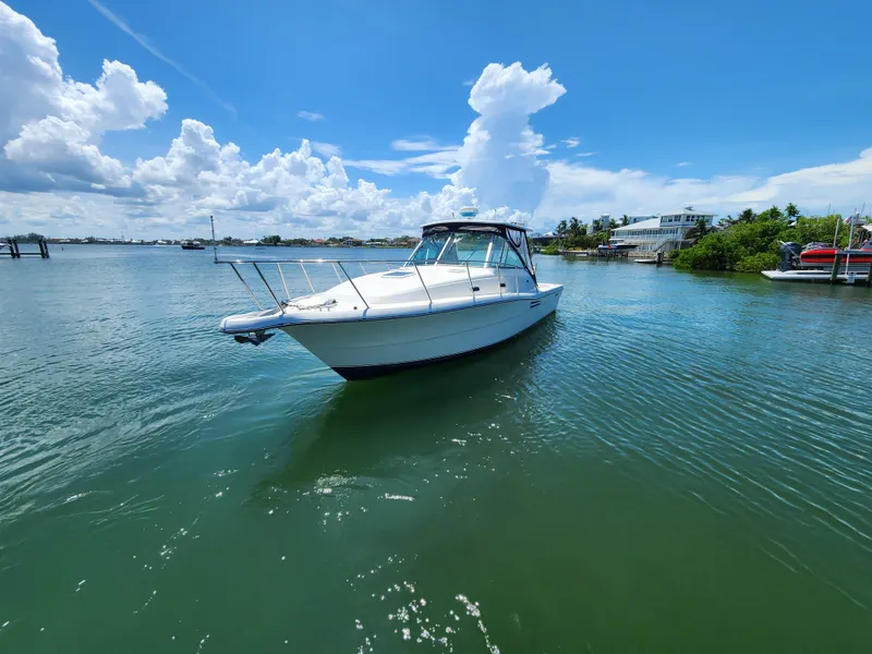 Slide: The Image of 2003 Pursuit 3000 Express boat on calm water under a clear blue sky. - 5