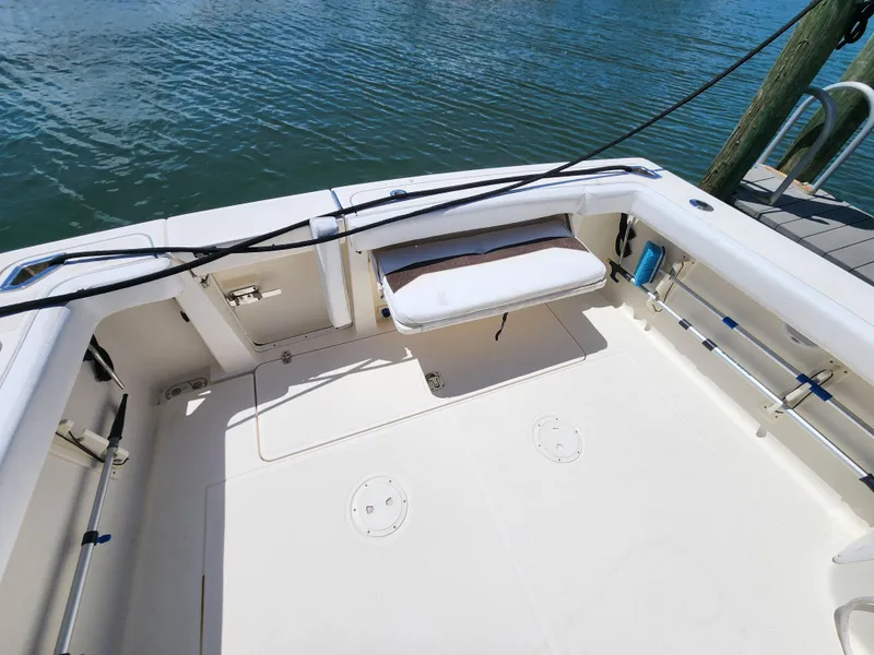 Slide: The Image of 2003 Pursuit 3000 Express boat deck with seating, docked by calm water. - 6