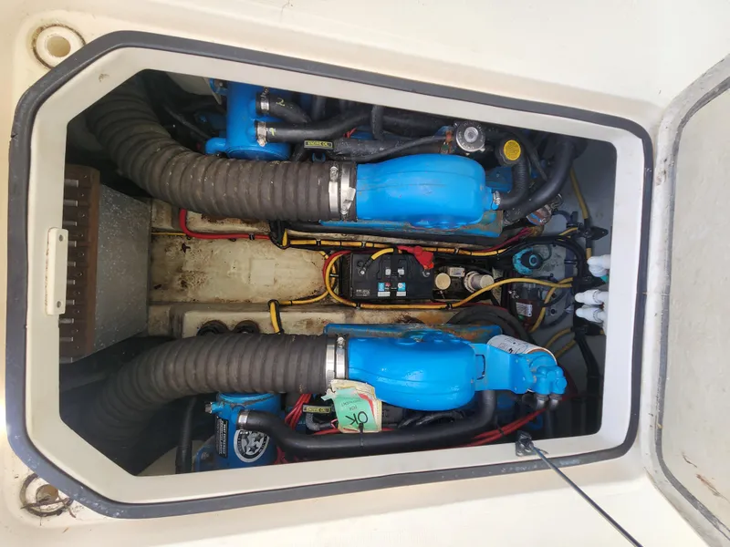 Slide: The Image of Engine compartment of a 2003 Pursuit 3000 Express boat, featuring blue engine components. - 7