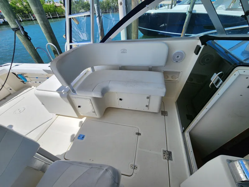 Slide: The Image of 2003 Pursuit 3000 Express boat interior with white seating and storage compartments. - 8
