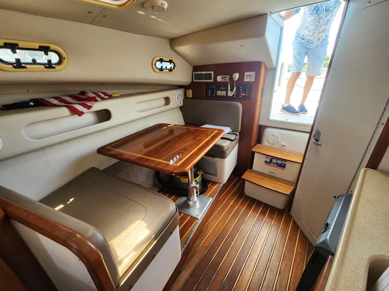 Slide: The Image of 2003 Pursuit 3000 Express cabin interior with wooden table and seating. - 9