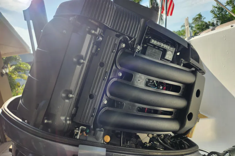 Slide: The Image of Close-up of a 2013 Hurricane SD2400 OB boat engine with sunlight and American flag in background. - 20