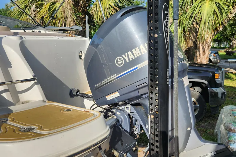 Slide: The Image of 2013 Hurricane SD2400 OB boat with Yamaha outboard motor, parked near palm trees. - 21