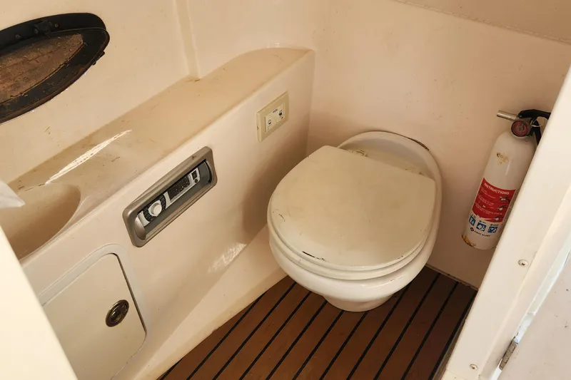 Slide: The Image of 2013 Hurricane SD2400 OB boat bathroom with toilet, fire extinguisher, and wooden floor. - 24