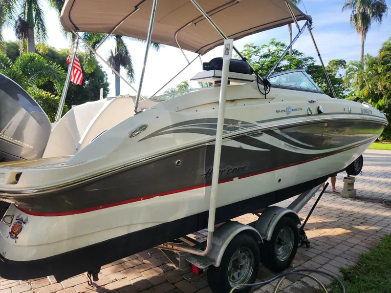 Slide: The Image of 2013 Hurricane SD2400 OB boat on trailer, surrounded by tropical trees. - 3