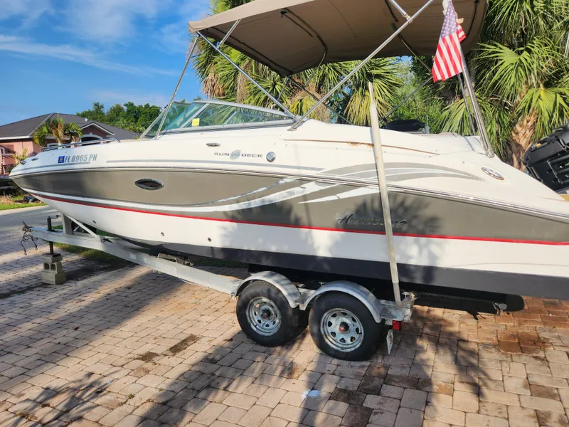 Slide: The Image of 2013 Hurricane SD2400 OB boat on trailer with American flag, parked on brick driveway. - 5