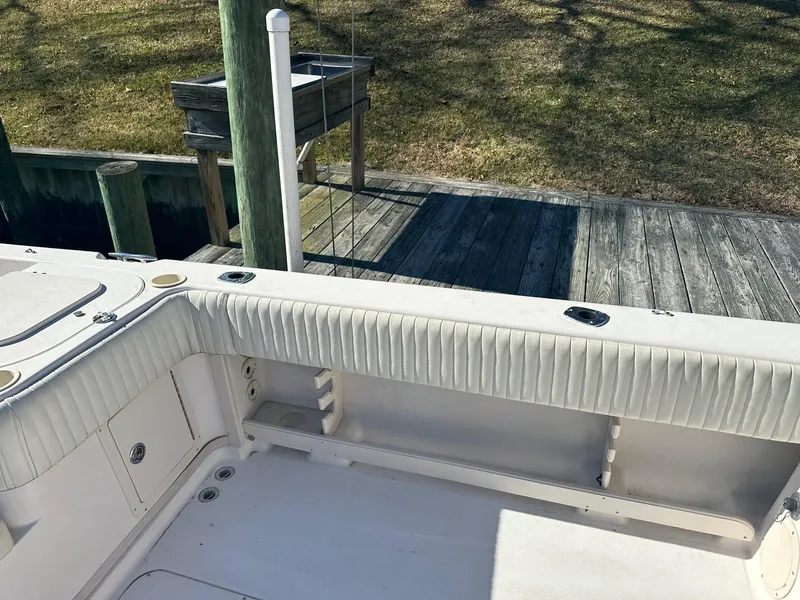 Slide: The Image of 2004 Grady-White Sailfish 282 WA boat interior with white seating and dock view. - 10