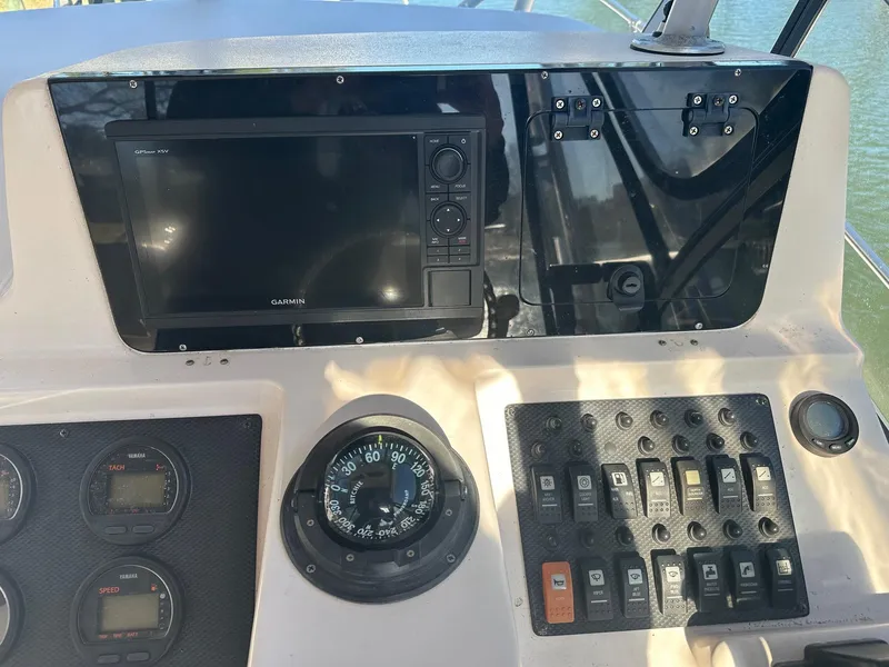 Slide: The Image of 2004 Grady-White Sailfish 282 WA dashboard with Garmin GPS, compass, and control panel. - 15