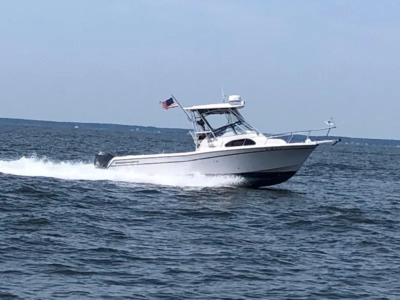 Slide: The Image of 2004 Grady-White Sailfish 282 WA cruising on open water with American flag. - 7