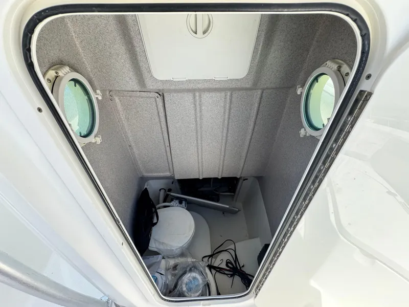 Slide: The Image of Interior of 2006 Bayliner 2503 Trophy Center Console boat with portholes and toilet. - 12