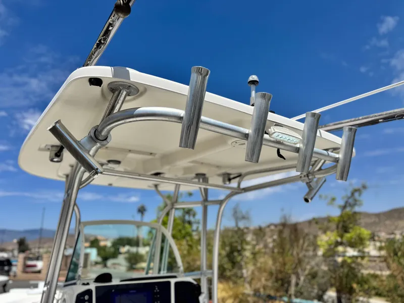 Slide: The Image of 2006 Bayliner 2503 Trophy Center Console boat with rod holders under a clear blue sky. - 17