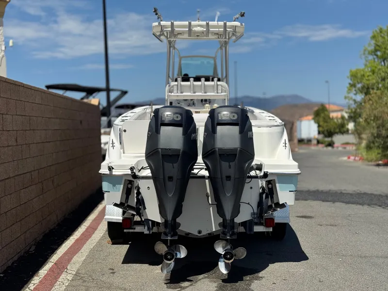 Slide: The Image of 2006 Bayliner 2503 Trophy Center Console with dual outboard motors, parked on a sunny day. - 4