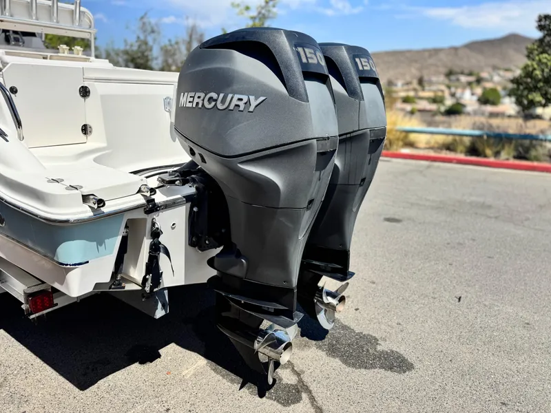 Slide: The Image of 2006 Bayliner 2503 Trophy Center Console with dual Mercury 150 engines, parked outdoors. - 7