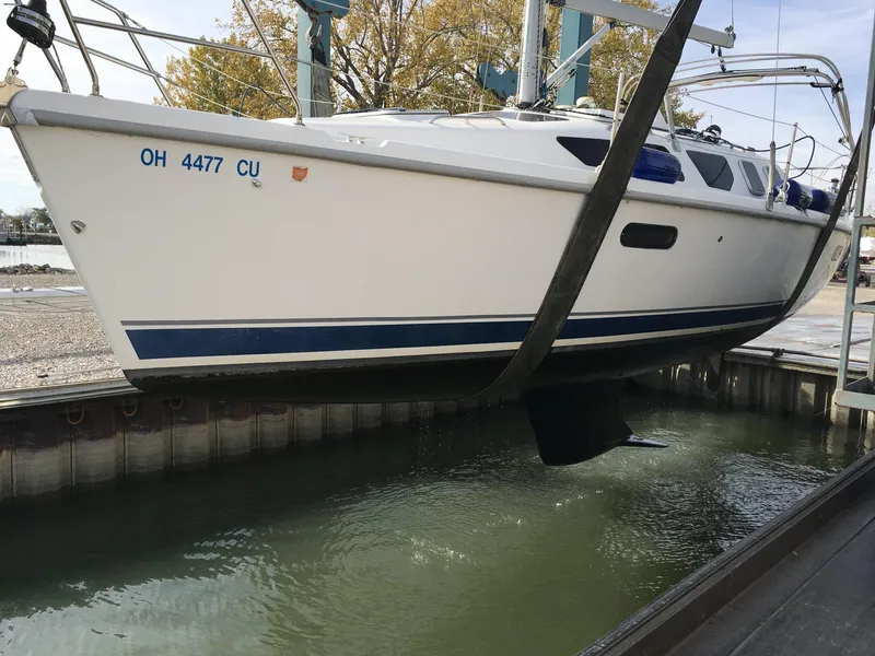 Slide: The Image of 2001 Hunter 320 sailboat being lifted from water at a marina. - 1