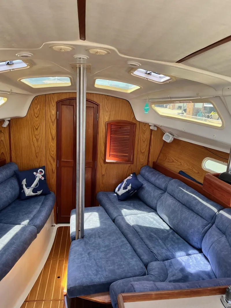 Slide: The Image of Interior of 2001 Hunter 320 sailboat with blue seating and wooden accents. - 13