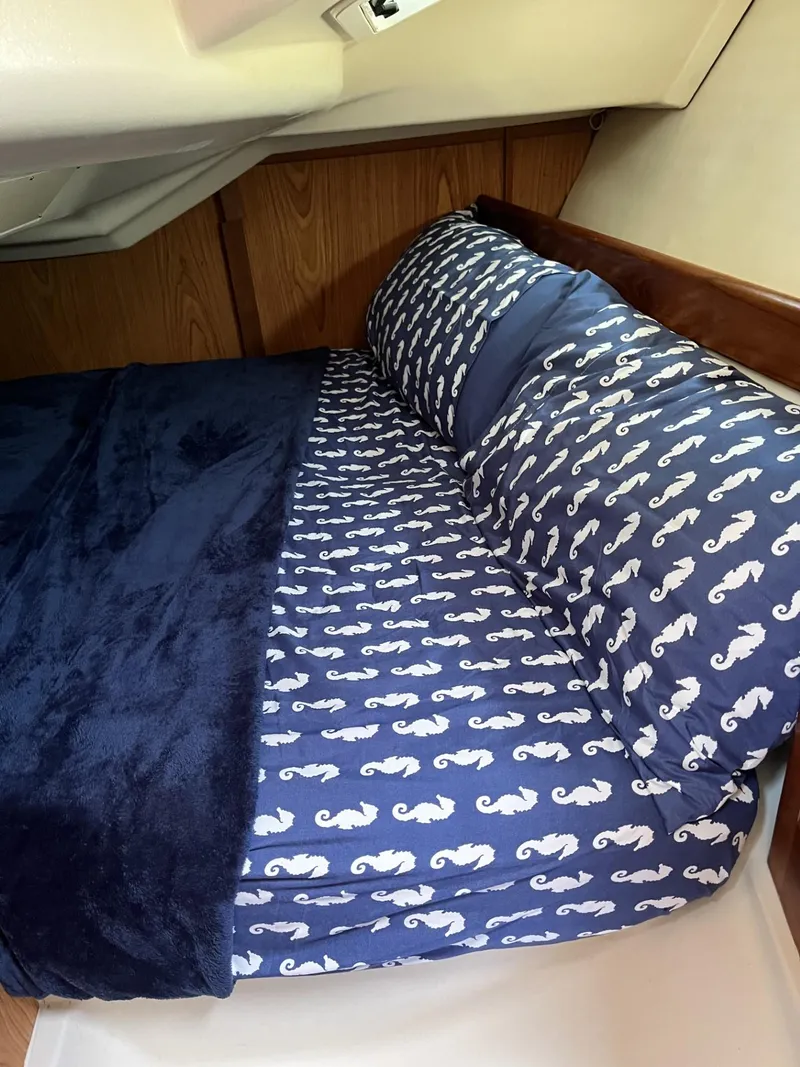 Slide: The Image of Cozy cabin bed in 2001 Hunter 320 sailboat with seahorse-patterned bedding. - 15