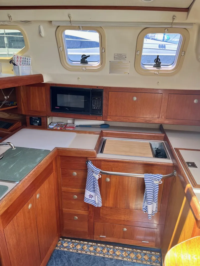 Slide: The Image of Interior of 2001 Hunter 320 sailboat galley with wooden cabinetry and microwave. - 16