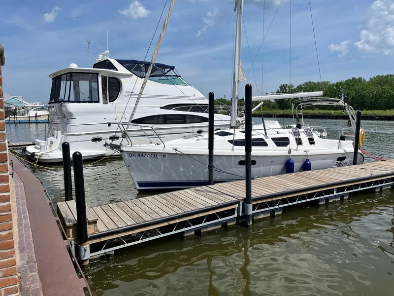 Slide: The Image of Sailboat Hunter 320 (2001) docked beside a larger yacht on a sunny day. - 6