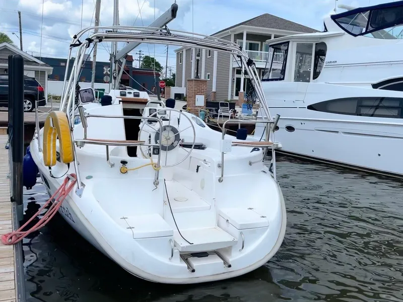Slide: The Image of 2001 Hunter 320 sailboat docked at marina, featuring spacious deck and modern design. - 7