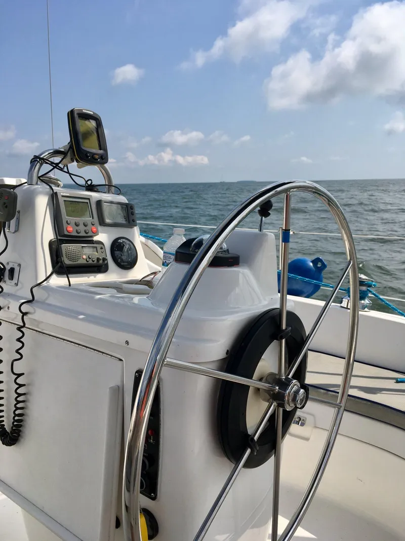 Slide: The Image of Sailboat cockpit with steering wheel and navigation equipment, Hunter 320, 2001 model, on open sea. - 9