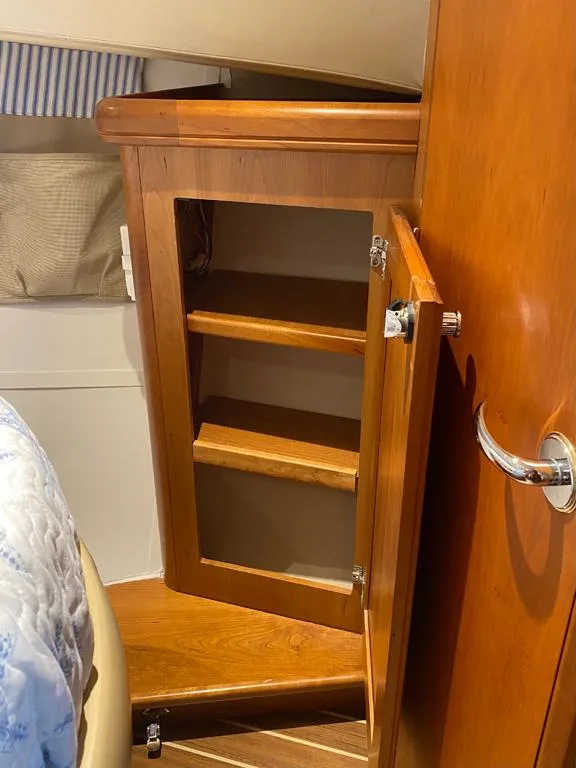 Slide: The Image of Wooden cabinet with open door inside a 2004 Mainship 340 boat interior. - 10