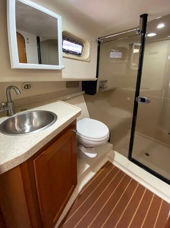 Slide: The Image of Bathroom interior of a 2004 Mainship 340 yacht with sink, toilet, and shower. - 12