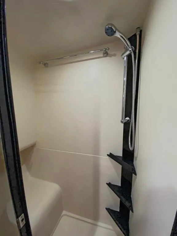 Slide: The Image of 2004 Mainship 340 shower area with handheld showerhead and built-in seating. - 13