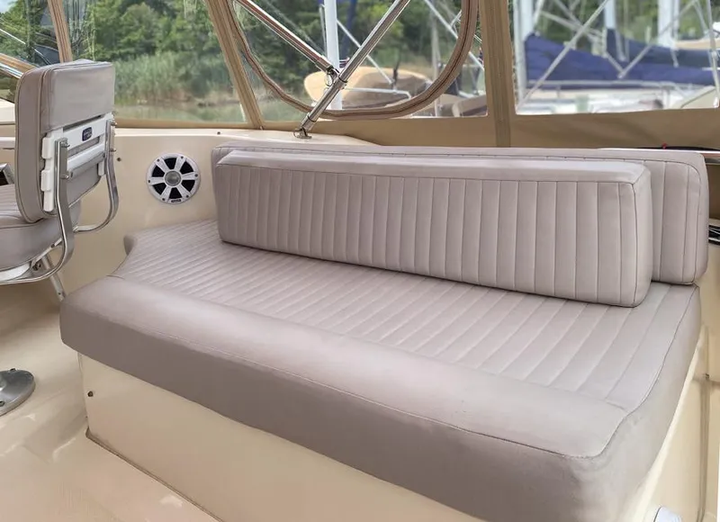 Slide: The Image of 2004 Mainship 340 boat interior with beige seating and speaker, showcasing comfort and style. - 16