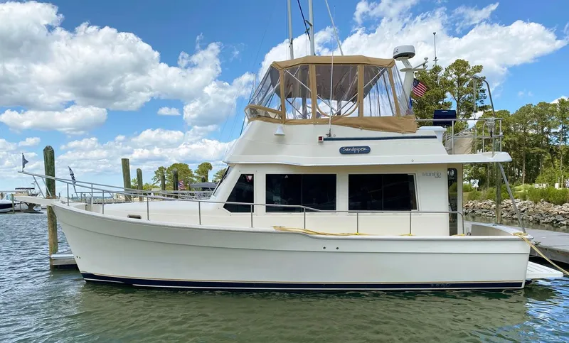 Slide: The Image of 2004 Mainship 340 yacht docked under a blue sky with clouds. - 20