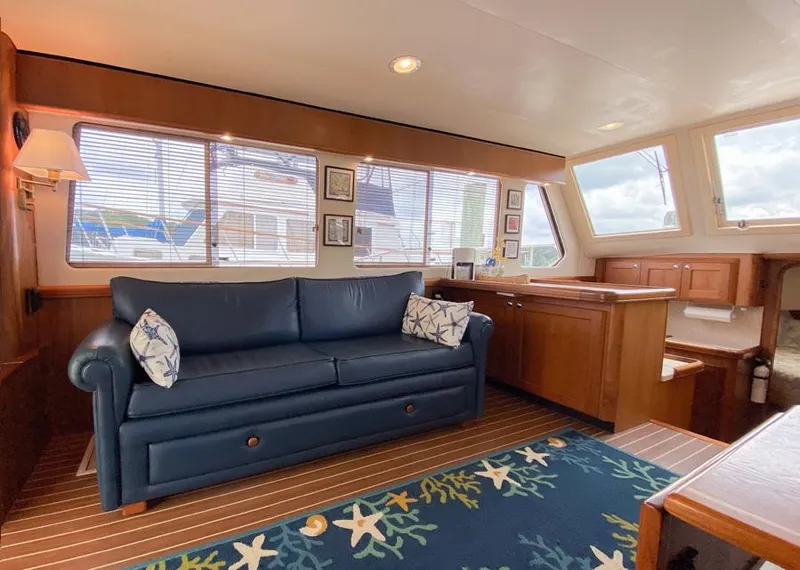 Slide: The Image of Interior of 2004 Mainship 340 yacht with blue sofa, wooden cabinetry, and nautical-themed decor. - 5