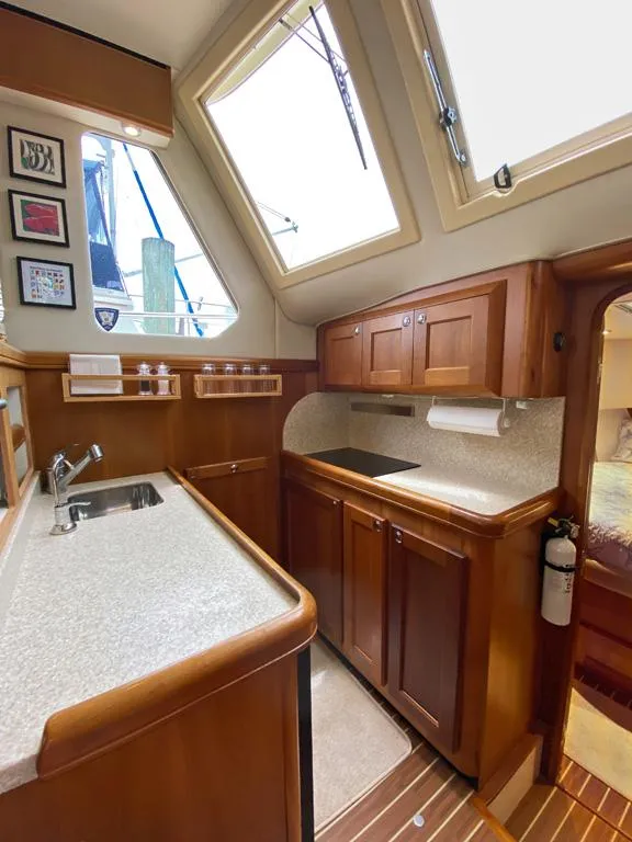 Slide: The Image of 2004 Mainship 340 yacht interior with wooden cabinetry, countertop, and windows. - 6