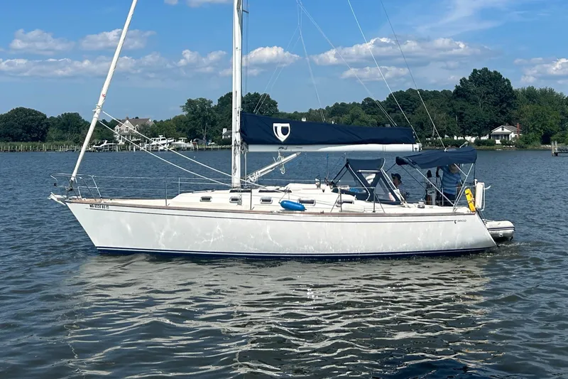 Slide: The Image of Sailboat Tartan 3500, 1998 model, cruising on a calm lake under a clear sky. - 0