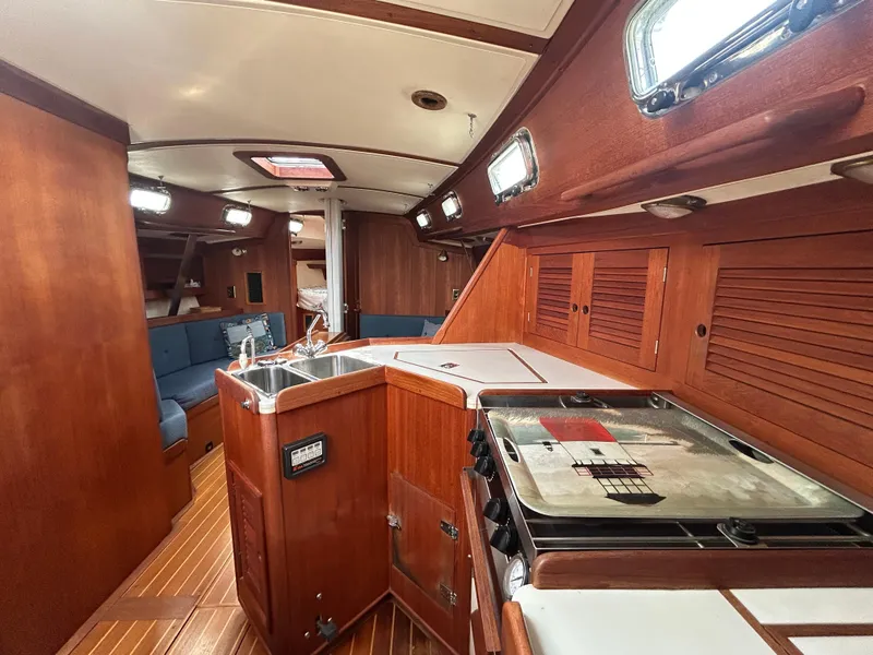 Slide: The Image of Interior of 1998 Tartan 3500 sailboat with wooden cabinetry and modern amenities. - 12