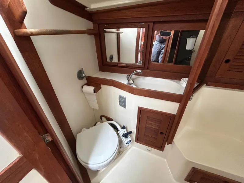 Slide: The Image of Compact bathroom in 1998 Tartan 3500 yacht with wooden accents and mirror. - 18
