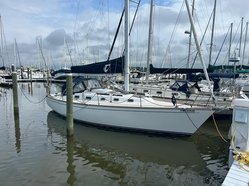 Slide: The Image of 1998 Tartan 3500 sailboat docked in a marina, surrounded by other boats. - 2