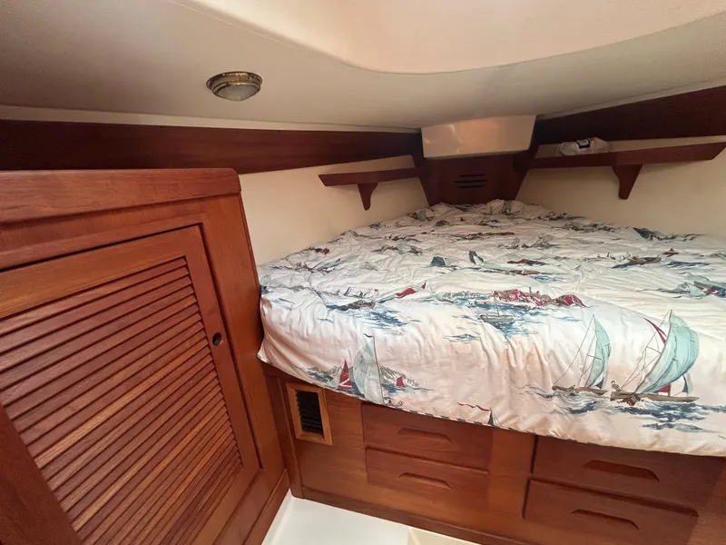 Slide: The Image of Cozy cabin interior of 1998 Tartan 3500 sailboat with nautical-themed bedding. - 21