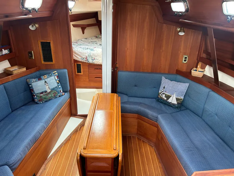 Slide: The Image of Cozy interior of 1998 Tartan 3500 sailboat with blue seating and wooden accents. - 5