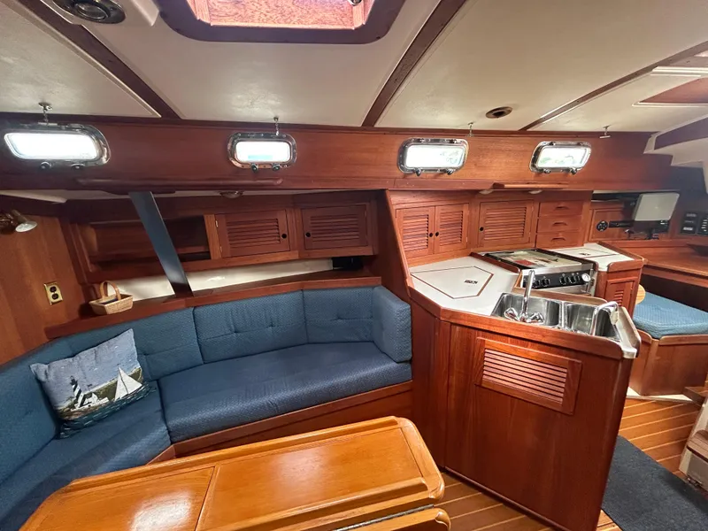 Slide: The Image of Interior of a 1998 Tartan 3500 sailboat with wood finish and blue seating. - 7