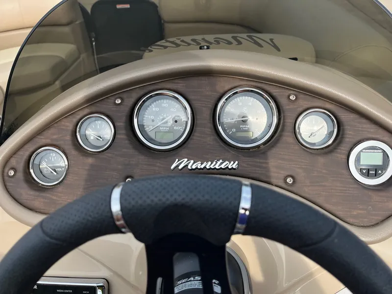Slide: The Image of Dashboard of 2018 Manitou 23 Oasis RF VP boat with gauges and steering wheel. - 12