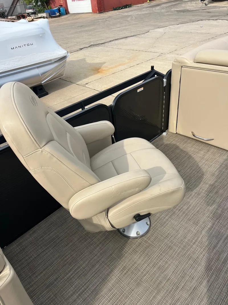 Slide: The Image of 2018 Manitou 23 Oasis RF VP boat interior with beige captain's chair. - 13