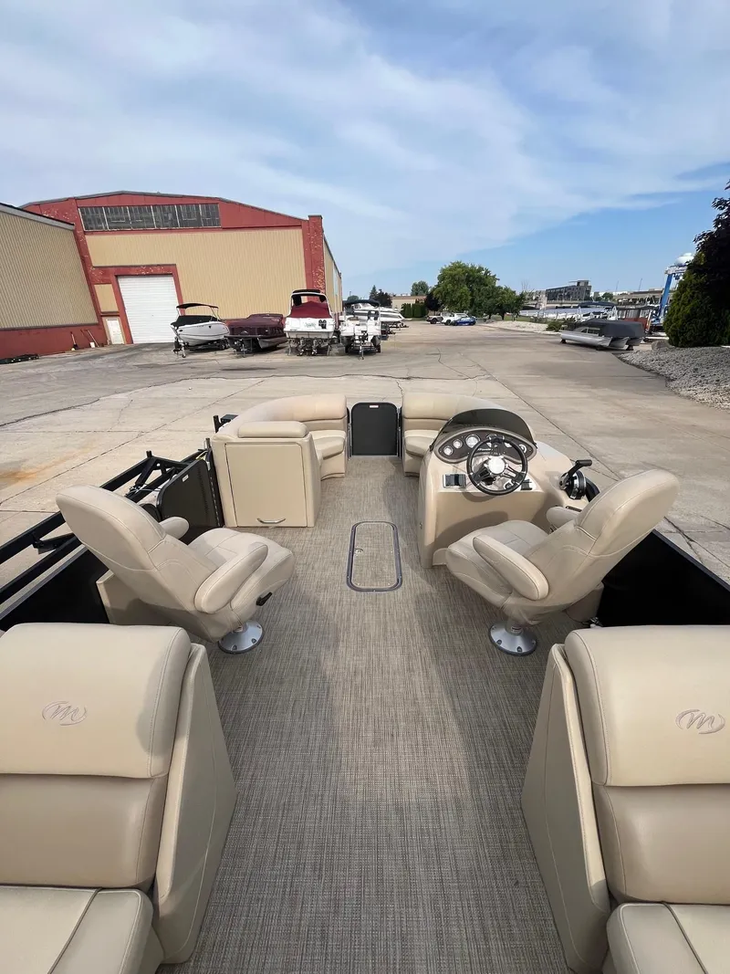 Slide: The Image of 2018 Manitou 23 Oasis RF VP pontoon boat with beige seating, docked at a marina. - 14