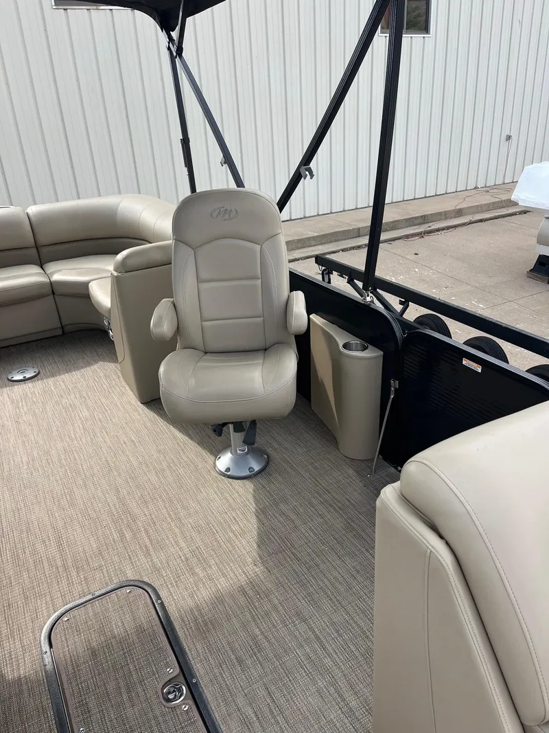 Slide: The Image of 2018 Manitou 23 Oasis RF VP boat interior with beige seating and carpet. - 19