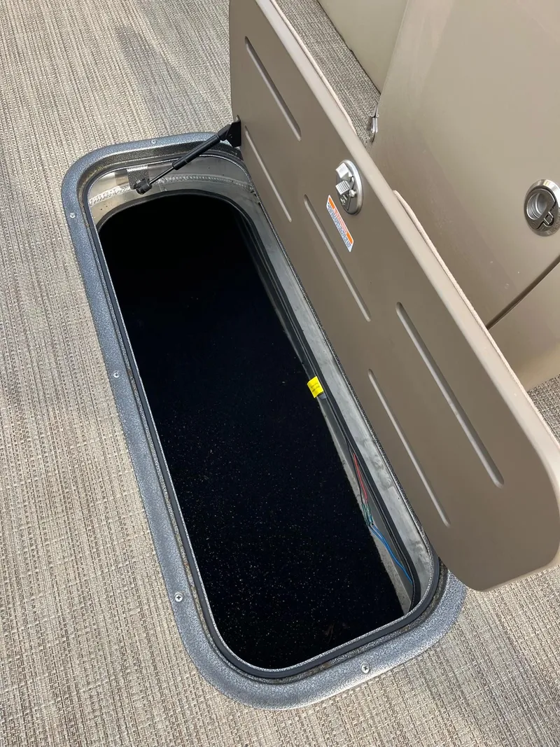 Slide: The Image of Open storage compartment on 2018 Manitou 23 Oasis RF VP boat. - 3