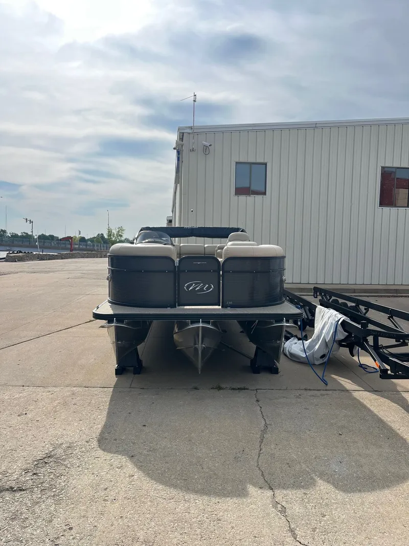 Slide: The Image of 2018 Manitou 23 Oasis RF VP pontoon boat parked on concrete near a building. - 7