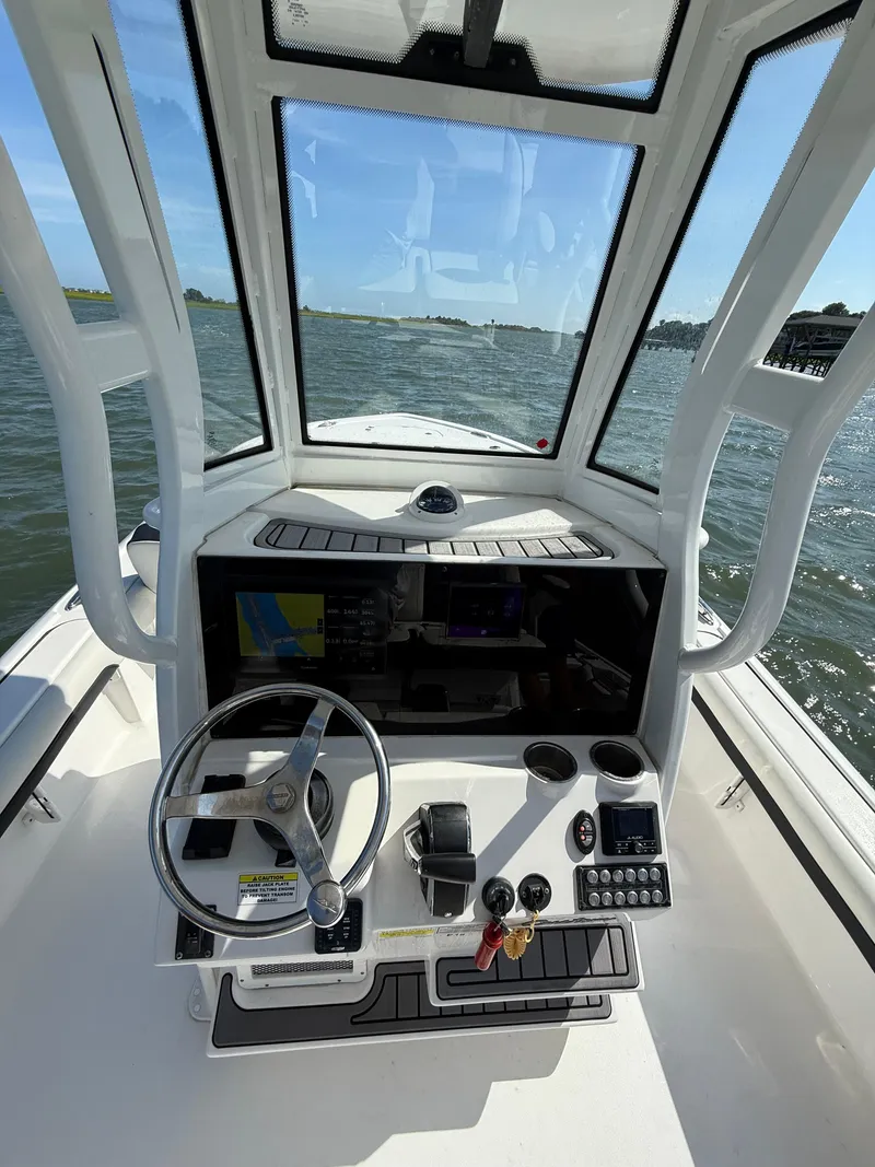 Slide: The Image of 2023 Tidewater 2500CB boat cockpit with steering wheel and navigation controls. - 11