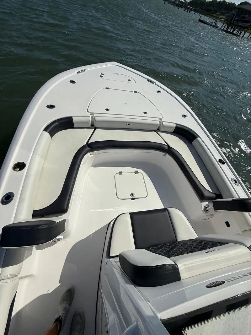 Slide: The Image of 2023 Tidewater 2500CB boat interior with cushioned seating on the water. - 18